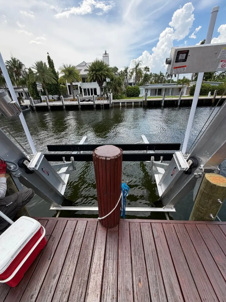 Finished aluminum elevator boat lift with rails and bunks in a Riviera Isles canal